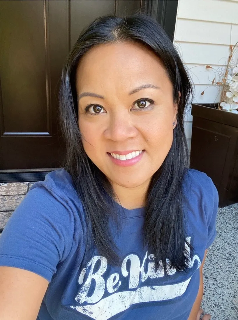 A woman with long black hair wearing a blue shirt.