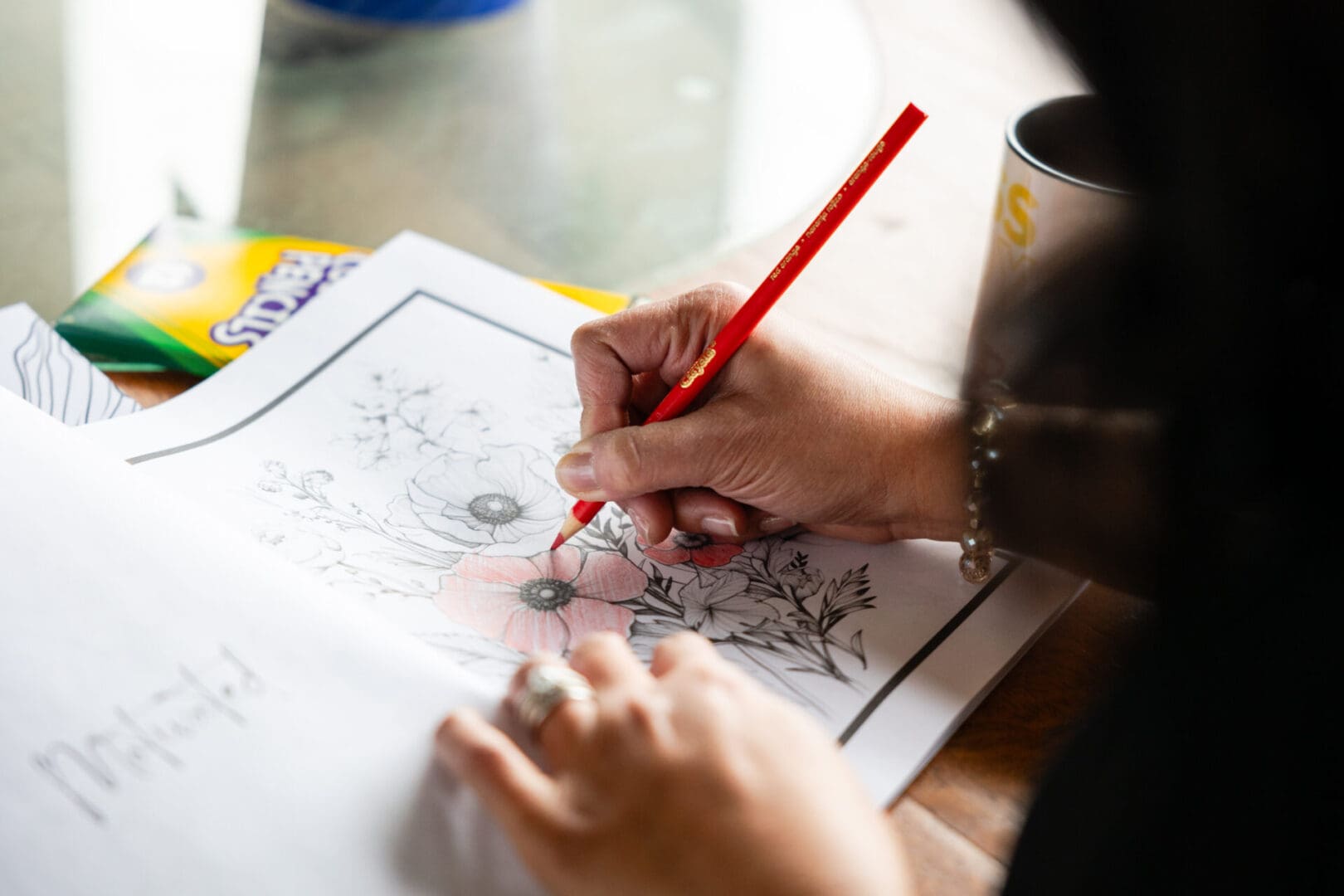 A person is drawing with a red pencil.