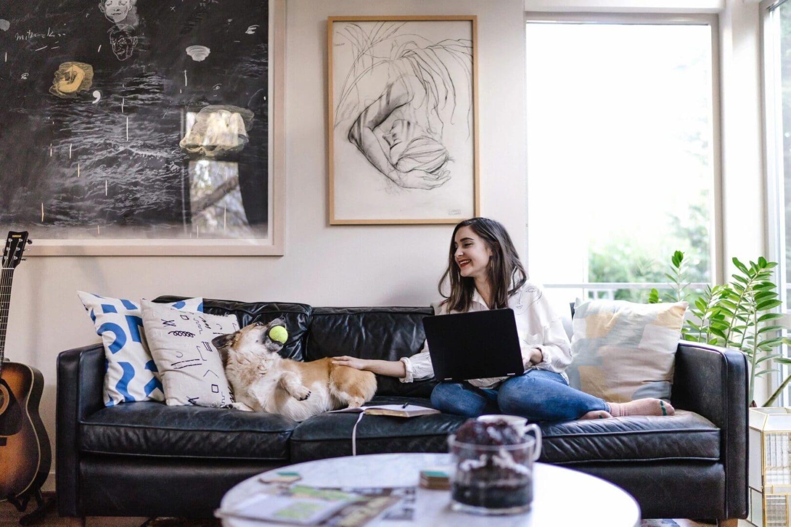 A woman sitting on top of a black couch.